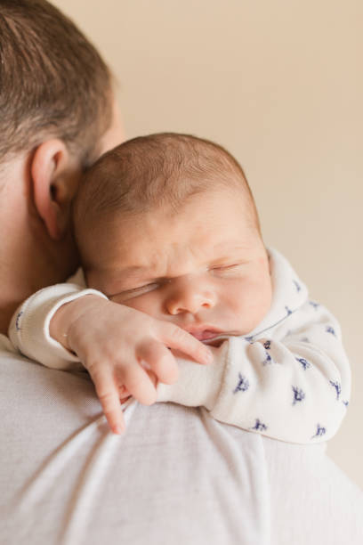 istock Newborn Baby Boy Asleep Over His Father's Shoulder 1364316743