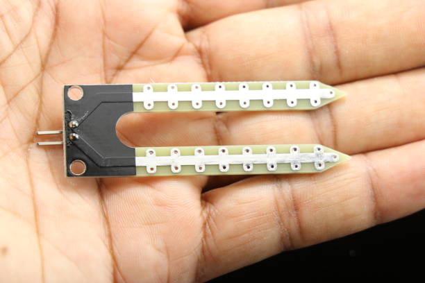 istock Close up of soil moisture sensor held in hand, Electronic sensor boards for prototyping innovative projects 1364316826