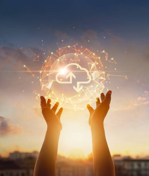 Cloud computing and networking concept. Hands touching global network and cloud icon on sunset background. stock photo