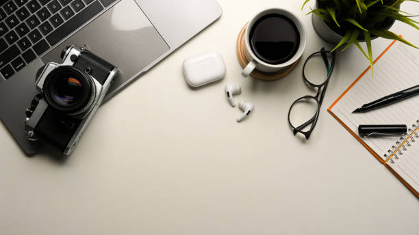 istock Photographer workspace with laptop, camera and copy space on white table. 1364320759