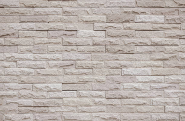 istock Cream and beige brick wall texture background. Brickwork and stonework flooring interior rock old pattern clean concrete grid uneven bricks office design. Background of old vintage brick wall backdrop 1364325803