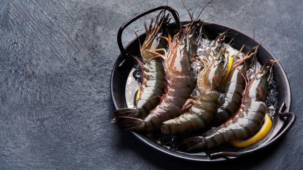 istock Raw shrimps on dark background. 1364328192