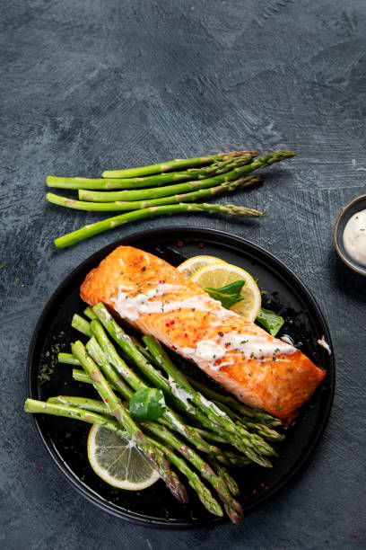 istock Baked salmon with asparagus on gray background. 1364328193