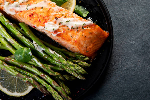 istock Baked salmon with asparagus on gray background. 1364328543