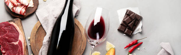 primitivo al vino rosso con antipasti su fondo grigio. - wine bottle bottle burgundy wine foto e immagini stock