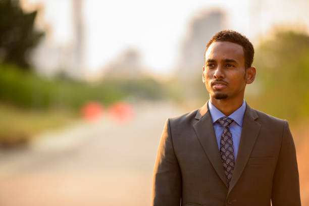 Handsome young African businessman wearing suit in city