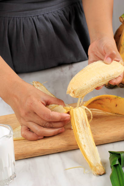 istock Peeling delicious banana she holds in her hand 1364332615
