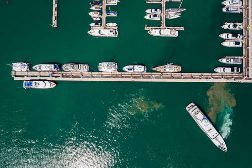 Top aerial view of a straight corner of a marina with boats