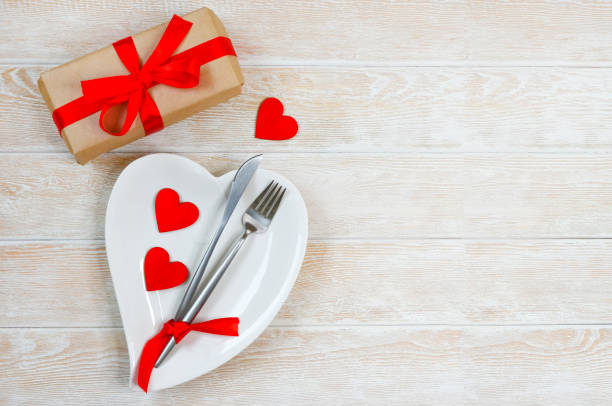istock valentines day table setting flat lay with love white ceramic plate shape heart, festive decoration, fork and knife and red eco friendly zero waste gift box copy space text 1364334414