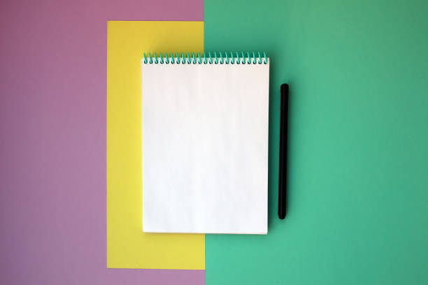 istock Bright stationery, notebook on pink yellow green background. Back to school, workspace concept. Top view, flat lay 1364334817
