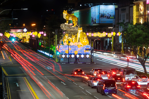 Singapore, Singapore - January 12, 2022: Vehicles move around large sculptures of tigers on a street in Chinatown, put up as part of Chinese New Year celebrations. 2022 marks the start of the Year of the Tiger.