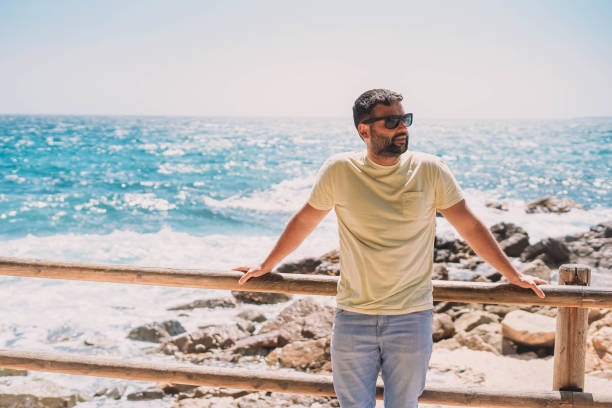 istock man enjoying a sunny day on the coast 1364337970