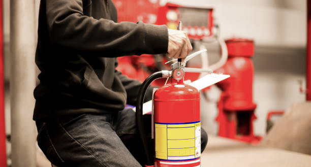 The red fire extinguisher is ready for use in case of an indoor fire emergency. stock photo