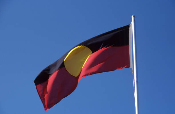 Australian Aboriginal flag blowing in a brisk breeze on a flagpole Hobart, Tasmania, Australia, October 9, 2006: View of the Australian Aboriginal flag blowing in a brisk breeze on a flagpole australian aborigine culture stock pictures, royalty-free photos & images