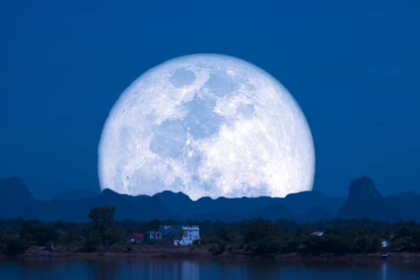 Full Snow Moon on night sky back silhouette mountain hill over lake, Elements of this image furnished by NASA