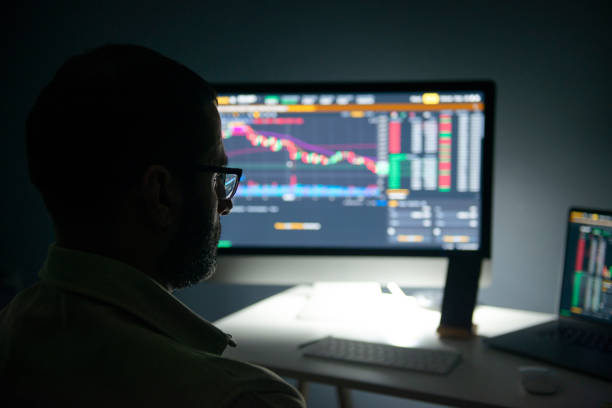 istock young male stock trader doing financial analysis examining financial data open on computer screen. 1364348265
