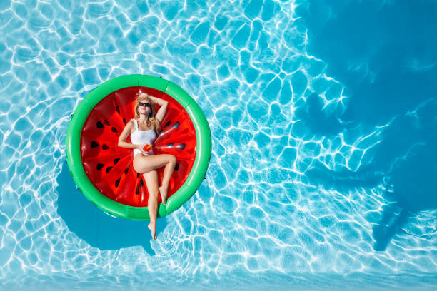 aerial top down view of a beautiful woman in bikini on a watermelon shaped float - bikini summer vacations looking down imagens e fotografias de stock
