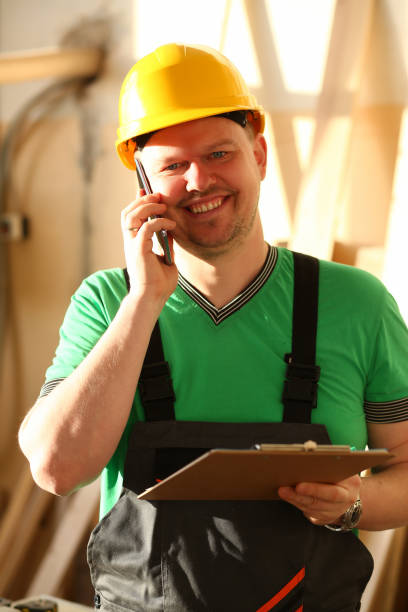 istock Carpenter in helmet talking on phone and taking order 1364352366