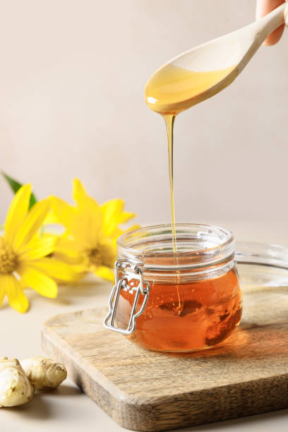 istock Pouring Jerusalem artichoke syrup in glass jar. 1364353846