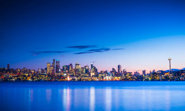 ligne d’horizon de la ville de seattle la nuit avec reflet dans l’eau. seattle, washington, états-unis. - seattle skyline mt rainier space needle photos et images de collection