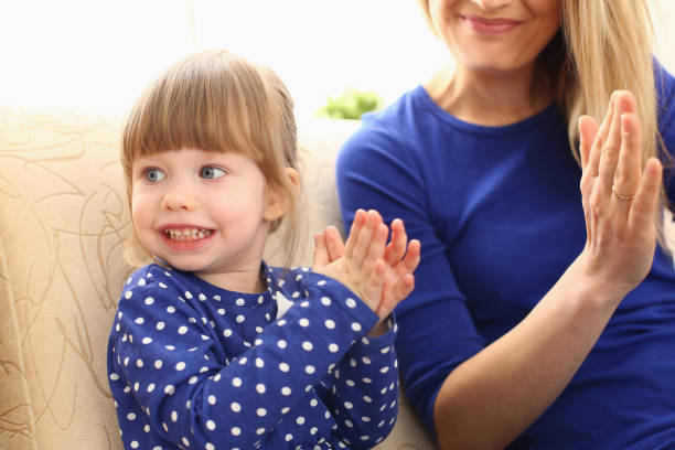 Cute little girl plays with mom and claps hands Cute little girl plays with mom and claps hands. Home games with young children concept riddle stock pictures, royalty-free photos & images