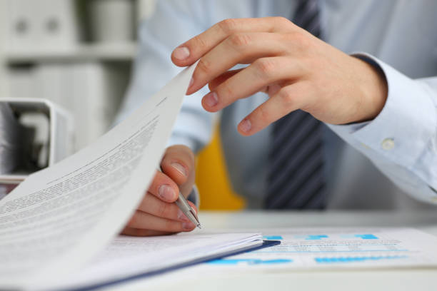 Male hands hold documents with financial statistics in closeup stock photo