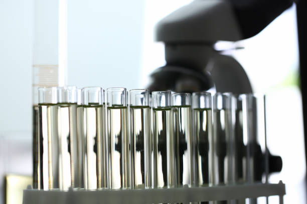 tubos de ensayo de vidrio con líquido amarillo en el microscopio - test tube glass reagent red fotografías e imágenes de stock