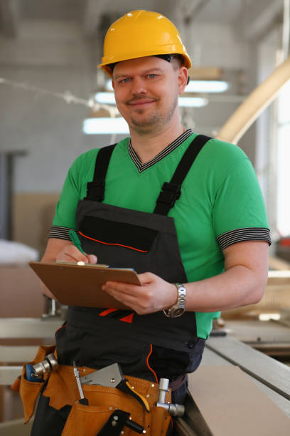 istock Worker in helmet and in uniform holds clipboard 1364354768
