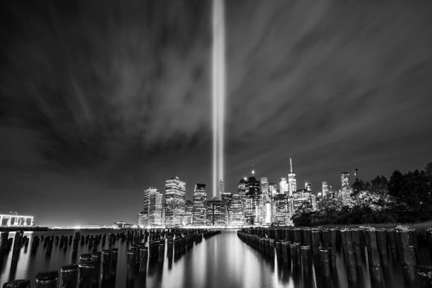 tribute in light, 911 memorial, skyline von new york city mit nächtlicher reflexion im wasser. - world trade center september 11 new york city manhattan stock-fotos und bilder