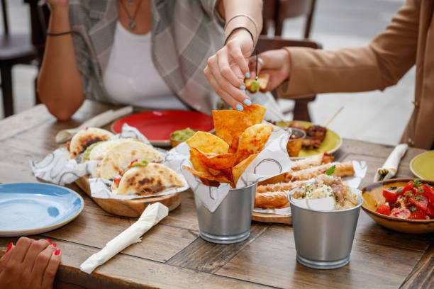 istock Taking tortilla chip from bowl and enjoying appetizers at restaurant table 1364356647