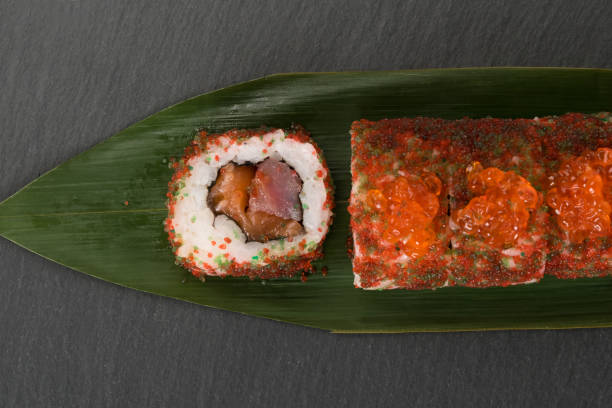 istock roll with red caviar and fish on a dark background 1364358178