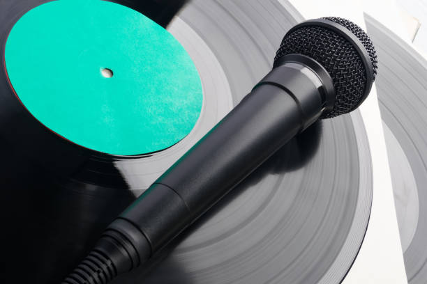 istock black microphone lies on an old vinyl record, close-up 1364358494