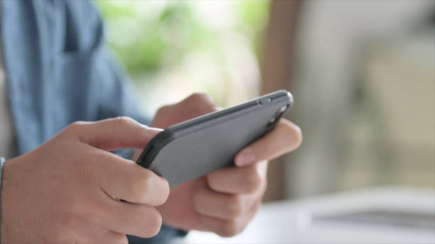 istock Close Up of Man Playing Game on Smartphone 1364360431