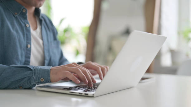 istock Hands of Man Typing on Laptop 1364360639