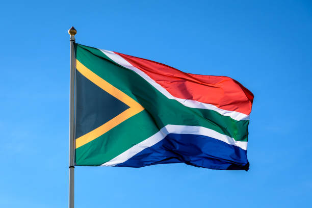 Flag of South Africa The flag of South Africa is flying in the wind at full mast against blue sky. south africa flag stock pictures, royalty-free photos & images