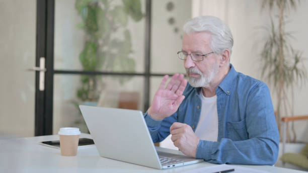 istock Senior Old Man Talking on Video Call on Laptop in Office 1364361733
