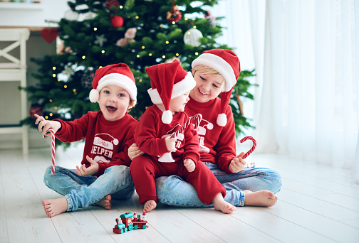 happy kids, siblings having fun together on christmas time, wearing funny Santa's helper sweaters