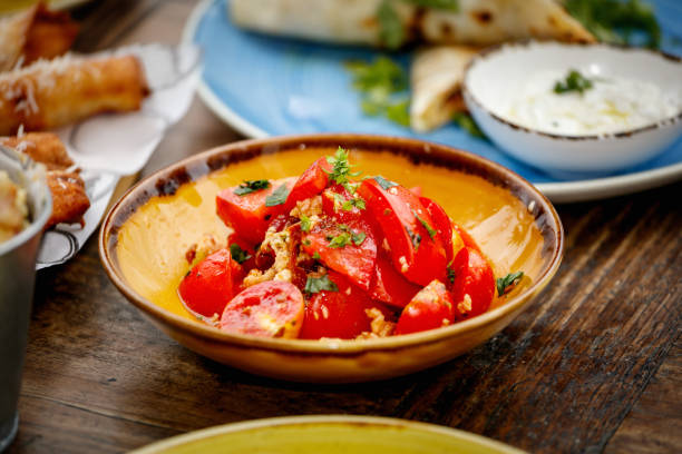 Chopped tomato with garlic, basil and parsley in plate on restaurant table, salad as side dish