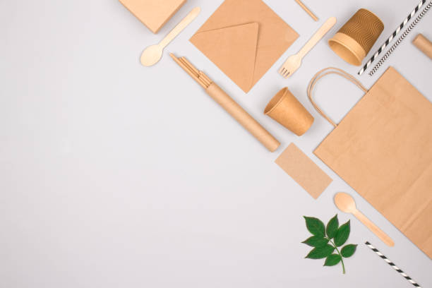 istock Different eco-friendly tableware and kraft paper food packaging on gray background. Street food paper packaging - cups, plates, straws, containers and paper bags. Mockup, flat lay 1364363712