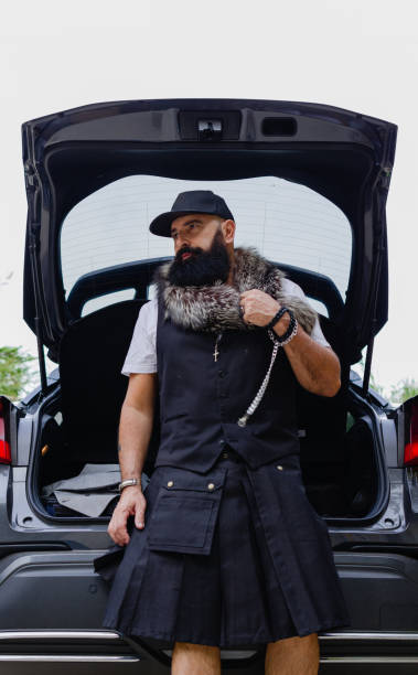 mature man with nice beard sitting on an opened car trunk