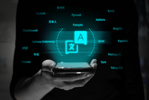 Una persona sostiene un teléfono inteligente con una proyección holográfica del símbolo de la aplicación del traductor. photo