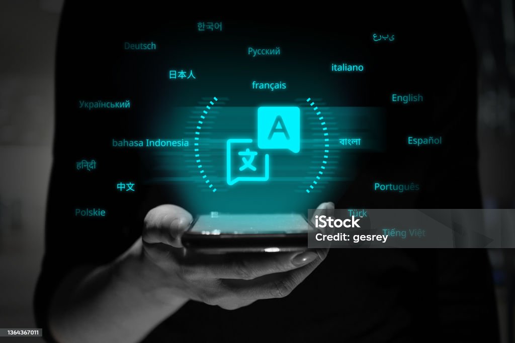 A person is holding a smartphone with a holographic projection of the translator application symbol. A person is holding a smartphone with a holographic projection of the translator application symbol Translation Stock Photo