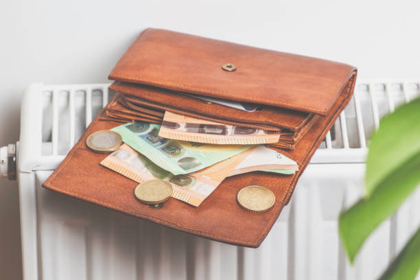 istock Expensive heating costs. Paying bills. Open wallet with Euro money banknotes on heating radiator battery at home 1364367152