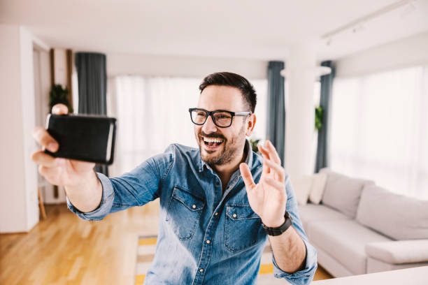 istock A smiling man taking selfie at his new cozy home. 1364368774