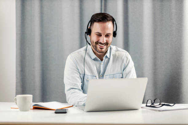 A male technical support agent sitting at home office and working from home. A male technical support agent sitting at home office and working from home. job fair photos stock pictures, royalty-free photos & images