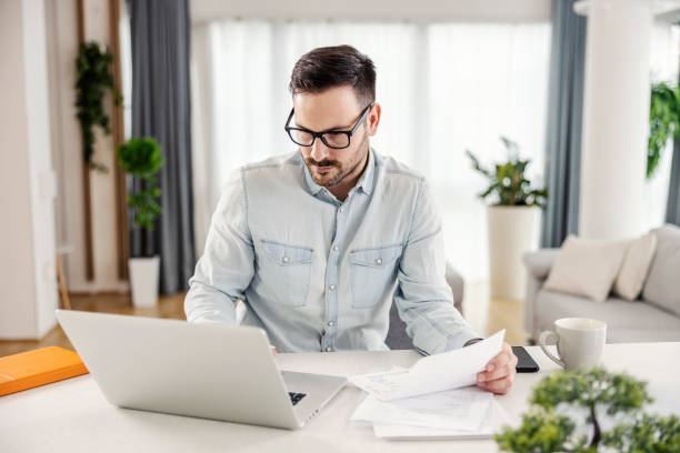 istock A man at his cozy home looking at the laptop, working on paperwork and solves home finances. 1364369818
