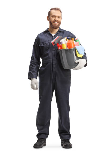 full length portrait of a male cleaner in a uniform holding a bucket of cleaning supplies and smiling - caretaker imagens e fotografias de stock