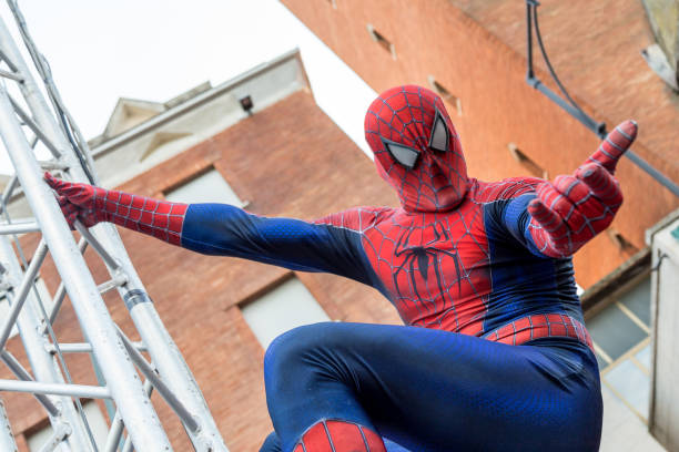 a man cosplaying the famous marvel comic character, spiderman during the carnival parade along the way of city of gaeta - spiderman stockfoto's en -beelden