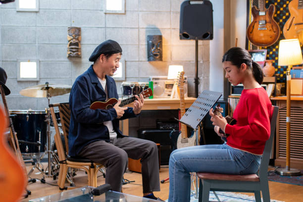 istock Pre-adolescent student learning how to play the ukulele 1364371927
