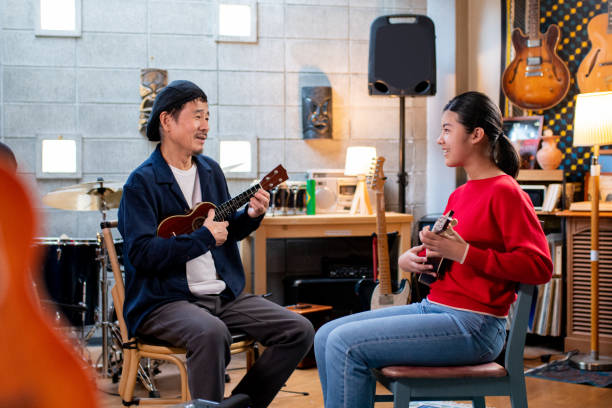 istock Pre-adolescent girl having ukulele lessons 1364371930